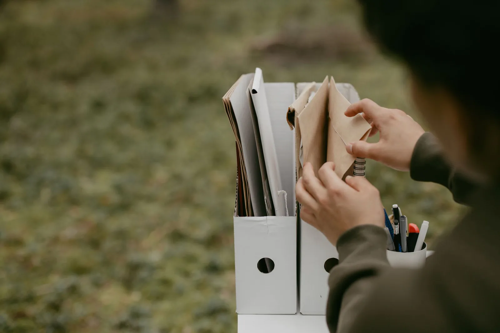 Person filing invoices and documents into storage boxes before selling a property