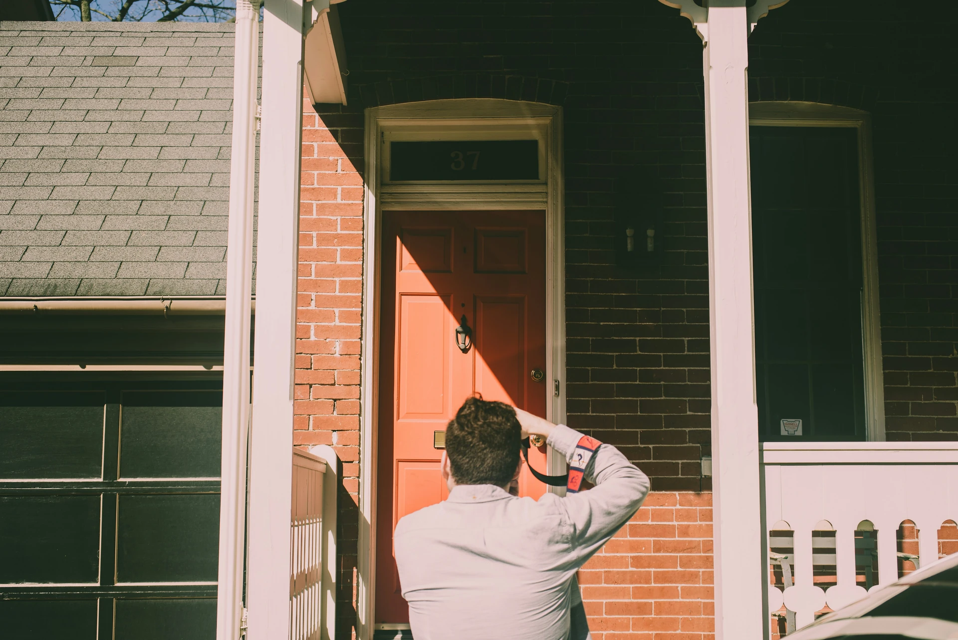 Visiteur devant la porte d'entrée d'une maison en brique avant une inspection préachat à Saint-Jérôme