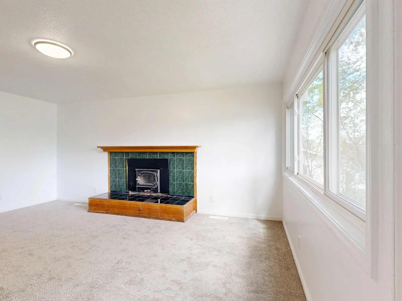Empty, uncluttered living room with a fireplace, a key step in preparing your home for sale in Saint-Jérôme